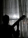 Man Silhouette Playing Guitar at Bedroom