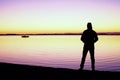 Man silhouette stand on stony beach and watching sunrise Royalty Free Stock Photo