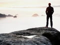 Man silhouette stay on sharp rock peak. Satisfy hiker enjoy view. Tall man on rocky cliff Royalty Free Stock Photo