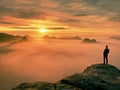 Man silhouette stay on sharp rock peak. Satisfy hiker enjoy view. Tall man on rocky cliff Royalty Free Stock Photo