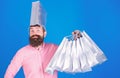 Man with silver bag on head going crazy about sales, fun and joy concept. Hipster in pink shirt with stylish beard doing