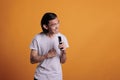 Man singing karaoke, grimacing, using smartphone as microphone Royalty Free Stock Photo