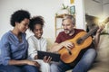 Man singing and playing guitar for his daughter and his wife Royalty Free Stock Photo