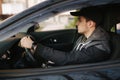 Man sit in the car. Handsome young man driving a car