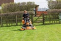 A man on a sit on lawn mower