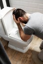 Man sit near the toilet and vomits Royalty Free Stock Photo