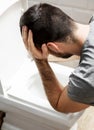 Man sit near the toilet and vomits Royalty Free Stock Photo