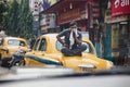 A man sit over the yellow vintage taxi on the street in Kolkata, India Royalty Free Stock Photo