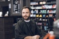 A man sits in a barber`s chair in a man`s barbershop, where he came to cut his hair. Royalty Free Stock Photo