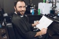 A man sits in a barber`s chair in a man`s barbershop, where he came to cut his hair. Royalty Free Stock Photo