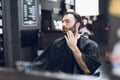 A man sits in a barber`s chair in a man`s barbershop, where he came to cut his hair. Royalty Free Stock Photo