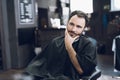 A man sits in a barber`s chair in a man`s barbershop, where he came to cut his hair. Royalty Free Stock Photo