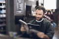 A man sits in a barber`s chair in a man`s barbershop, where he came to cut his hair. Royalty Free Stock Photo