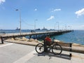 A man sits on a bench behind a bicycle gazes towards the sea at Molos promenade in Limassol, Cyprus