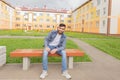 Man sits on a bench in the yard of new houses Royalty Free Stock Photo