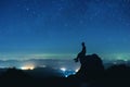 Man sits on big rock on night sky background