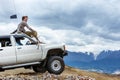 Man sits on the car SUV the mountains wheel Royalty Free Stock Photo