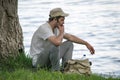 Young man is resting near a tree on the river Bank Royalty Free Stock Photo