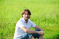 Man sits in the grass in the summer Royalty Free Stock Photo