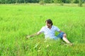 Man sits in the grass in the summer Royalty Free Stock Photo