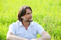 Man sits in the grass in the summer Royalty Free Stock Photo