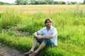 Man sits in the grass in the summer Royalty Free Stock Photo