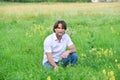 Man sits in the grass in the summer Royalty Free Stock Photo