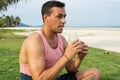 The man sits on a grass in the tropical country of the island Samui, the Man drinks smoothie. Royalty Free Stock Photo