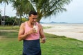 The man sits on a grass in the tropical country of the island Samui, the Man drinks smoothie.