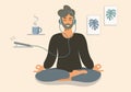 A man sits in a lotus position, does yoga and listens to audio on his phone. Hipster in headphones meditates with a cup Royalty Free Stock Photo