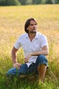 Man sits near a wheat field Royalty Free Stock Photo