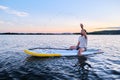 A man sits on a paddle board at sunset. Royalty Free Stock Photo