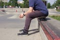 A man sits on a skateboard on the background of a skatepark. Feet close up. lifestile concept.