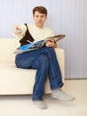 Man sits on sofa with newspaper and remote control Royalty Free Stock Photo