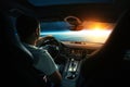 Man sits in a spaceship car and flies to the planet with a sunset in space. Space travel by car, concept. Driver behind the wheel