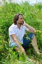 Man sits in the tall grass in summer Royalty Free Stock Photo