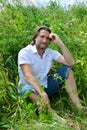 Man sits in the tall grass in summer Royalty Free Stock Photo