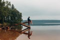 Man sits on a wooden bridge waits when the fish are biting. Royalty Free Stock Photo