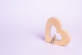 A man sits on a wooden heart and waits. A lonely person is looking for a soul mate, a partner. Site for dating.