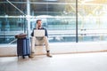 Man sitting at the airport using laptop and mobile phone next to