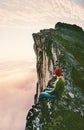 Man sitting alone on the edge mountain ridge above clouds Royalty Free Stock Photo