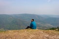 Man sitting alone at hill top with misty mountain rage background from flat angle Royalty Free Stock Photo