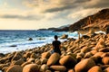 A Man Sitting Alone with His Thoughs at A Wild Eggshaped Rocks Beach with Dramatic Clouds in The Sky