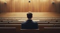 A Man Sitting Alone in a Large Lecture Hall