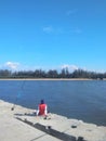 Man sitting alone on pier fishing Royalty Free Stock Photo