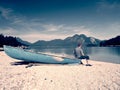 Man sitting on alpine mountain lake bank at anchored boat. Royalty Free Stock Photo