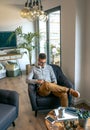 Man sitting in an armchair with tablet Royalty Free Stock Photo