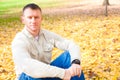 Man Sitting on Autumn Leaves Royalty Free Stock Photo