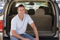 Man sitting in back of van smiling Royalty Free Stock Photo