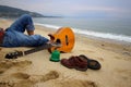 Man sitting on the beach with guitar and shoes. Royalty Free Stock Photo